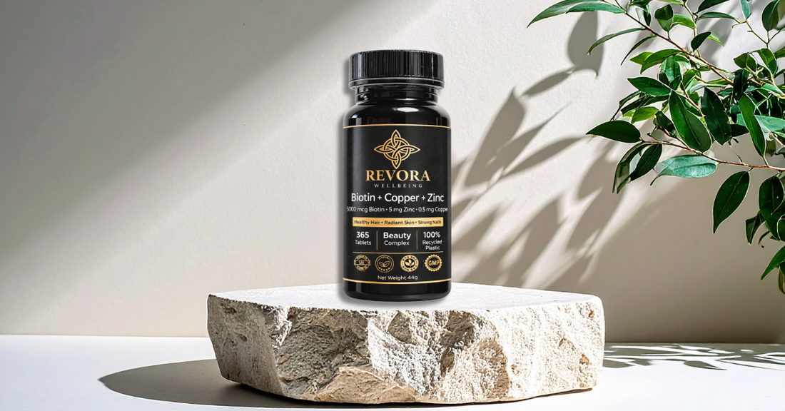 Revora Wellbeing Biotin Copper and Zinc supplement bottle on a stone surface with soft botanical light